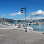 Charter yachts moored along the quay of a marina in Lefkada, Greece