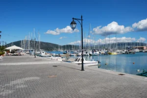 Charter yachts moored along the quay of a marina in Lefkada, Greece