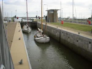 Sailing yachts in the lock at Kornwerderzand on the Afsluitdijk, Netherlands