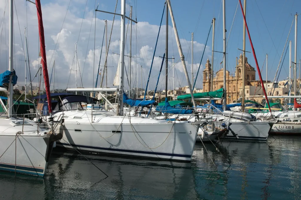 Sailing yachts moored in Msida Marina, Malta, with the parish church behind
