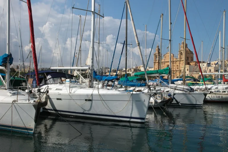 Sailing yachts moored in Msida Marina, Malta, with the parish church behind
