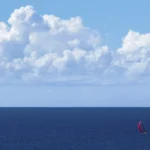 Sailing yacht with a red spinnaker on the open ocean