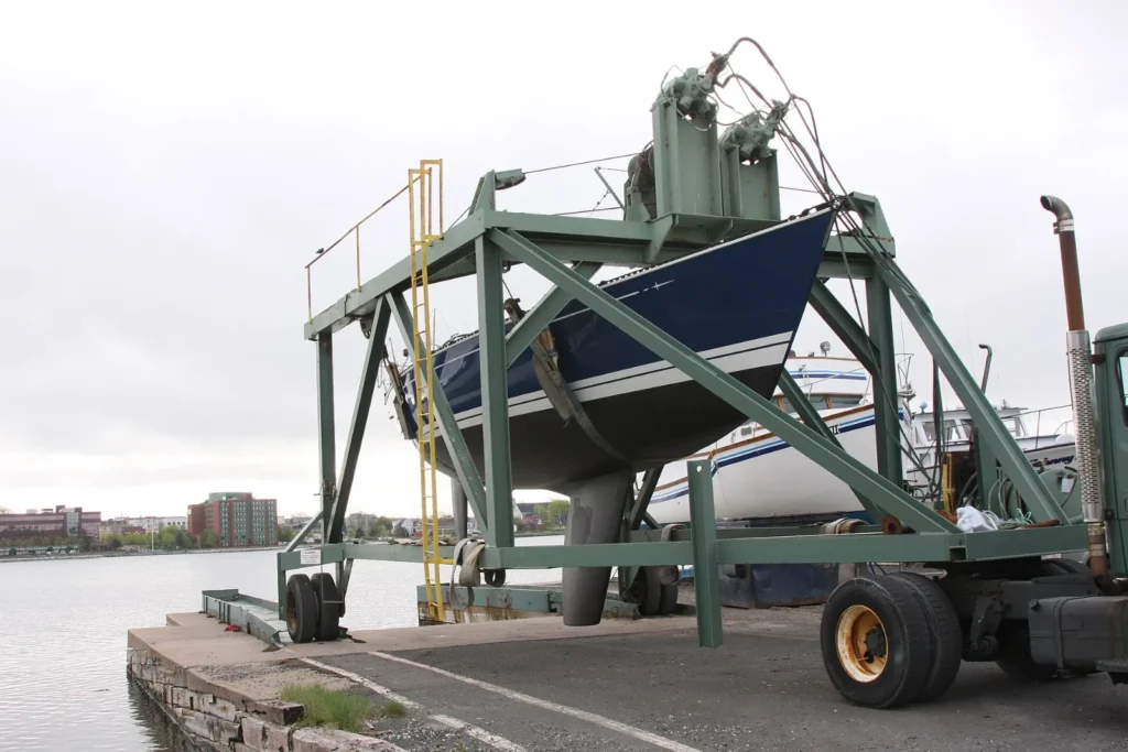 Yacht lifted out of the water by a travel lift in a boatyard