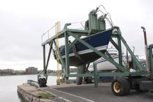 Yacht lifted out of the water by a travel lift in a boatyard