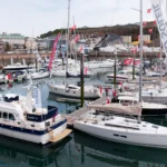 Sailing and motor yachts on display at a boat show marina