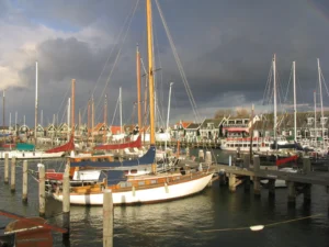 Sailing yachts moored at a marina pontoon under a dramatic sky